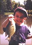 Joseph Morganti at 2 1/2 years old with his first fish --  a 12 inch White Crappie. He caught it on a Bomber FAT "A" size 3F, Baby Bass color on August 20, 2000 in a small pond in Mayville, New York. 