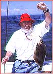 Curt Garfield with his tradition red hat holding up a nice Montauk Fluke