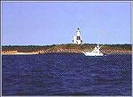 A sportfisherman trolling in Front of historic Montauk Light. Copyright 1998 by Mike Plaia