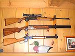 A gun rack I bought many years ago, it secures 3 rifles/shotguns to the wall using a trigger locking mechanism. Steel plate behind wood veneer is lagbolted to the studs in the wall. Makes for a nice a