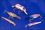 A few odd bass lures including the Big Bud and two Storm Thundersticks (one in Patriot pattern and one in Desert Camo) and two Storm Hot-N-Tots in the same patterns.