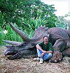 Steven Spielberg posing with an animated dinosaur.